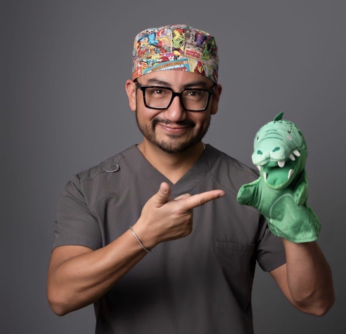 Dr. Alex Miranda, pediatra y cirujano pediatra, con un títere de cocodrilo