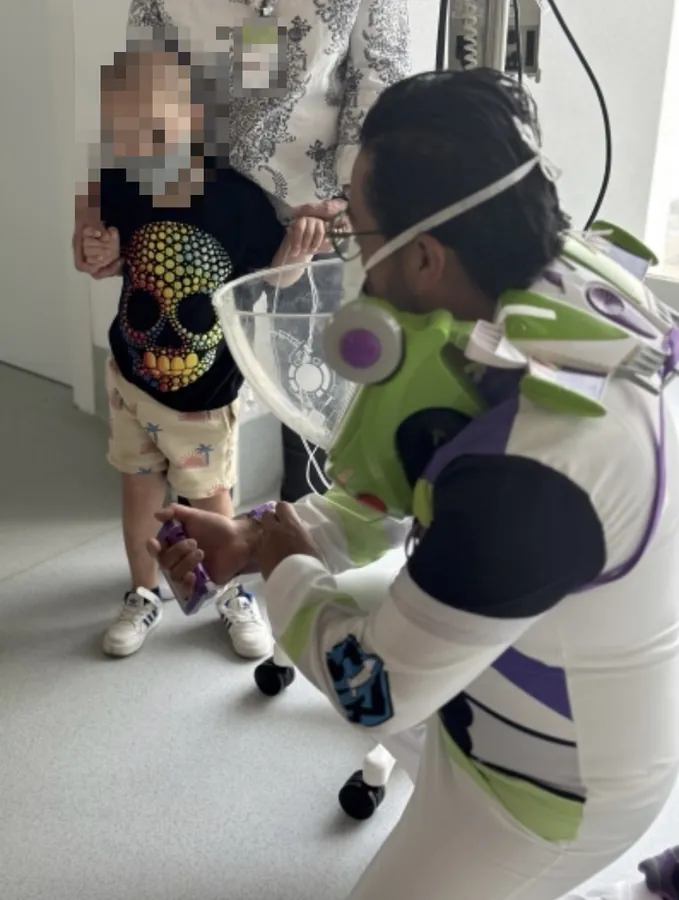 El Dr. Alex Miranda disfrazado de astronauta visitando a un paciente